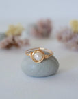 Front view of a minimalist pearl wire wrapped ring in 14k gold filled wire
