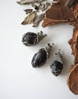 Three apache tears obsidian pendants – showing natural variation in size, shape, and color, handcrafted unisex volcanic glass jewelry.