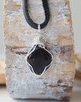 Back view of handcrafted men's black onyx necklace – natural stone and wire wrapping, July birthstone, flat black leather cord.