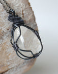Right angle close-up of clear quartz pendant for men – showcasing artisan wire wrapped gunmetal copper, natural crystal.