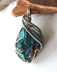 Front angle close-up of peacock ore pendant for men – detailed white gold copper wire wrapping, iridescent crystal, Capricorn and Cancer birthstone.