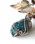 Left angle close-up of peacock ore pendant for men – highlighting unique wire-wrapped artistry, white gold copper, Capricorn and Cancer birthstone.
