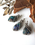 Three peacock ore pendants for women – showing natural variation in size, shape, and iridescent colours, white gold copper wire wrapping.
