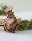 Right angle close-up of sardonyx necklace – highlighting unique wire-wrapped artistry, raw sardonyx crystal, gender-inclusive jewelry.