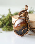 Left angle close-up of sardonyx necklace – artisan wire wrapping, banded natural stone, August birthstone pendant by Designs by Nature Gems.