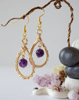 Front view of amethyst drop earrings with 8mm polished amethyst bead in gold plated copper wire wrapped teardrop dangle design