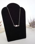 Right angle view of amethyst and freshwater pearl bar necklace in 925 sterling silver on jewelry display