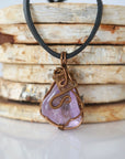 Back view of mens amethyst wire wrapped pendant — bronze copper finish hand-wrapped setting shows craftsmanship and secure stone hold, handmade in Toronto Canada