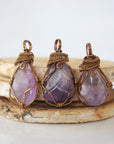 Multiple mens amethyst pendants showing natural variation in stone size, shape, and lavender colour — each one of a kind, February birthstone, bronze copper wire wrapped, Designs by Nature Gems
