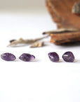 Two pairs of amethyst stud earrings showing natural variation in stone size, shape, and color, sterling silver posts