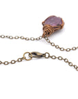 Close-up of antique bronze lobster clasp and cable chain on handmade raw ruby necklace — nickel-free jewelry detail