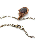 Close up of antique bronze copper chain lobster claw closure for natural garnet necklace