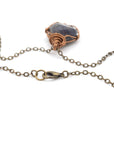 Close-up of antique bronze lobster clasp chain closure on a handcrafted raw sapphire necklace by Designs by Nature Gems
