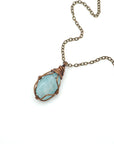 Genuine aquamarine necklace laying flat with antique bronze wire wrapping and chain, Designs by Nature Gems