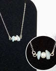 Close-up of raw aquamarine stones and freshwater pearl bar on 925 sterling silver necklace