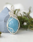 Right side view of aquamarine pendant showing intricate artisan wire wrapping and natural crystal shape