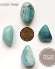 Four natural aquamarine stones showing variation in size, shape, and color for an aquamarine pendant necklace