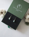 Aquamarine sterling silver drop earrings in branded Designs by Nature Gems jewelry box, showcasing handcrafted faceted aquamarine and sterling silver wire wrapping