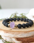 Left side angle of black lava bead stretch bracelet with raw amethyst focal stone and pyrite crystal beads