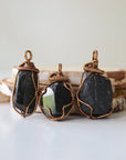 Three raw black tourmaline pendants showing natural stone variation in size and shape, artisan jewelry by Designs by Nature Gems.