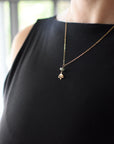 Emerald and lotus necklace for women worn on female model with natural emerald bead and gold vermeil lotus pendant