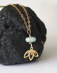 Right angle detail of emerald and lotus necklace for women with faceted emerald bead and artisan gold vermeil lotus design