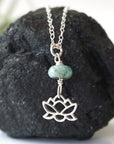 Emerald and lotus necklace for women with natural faceted emerald bead and sterling silver lotus charm, detailed front view