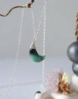 Right angle detail of emerald moon necklace for women with natural faceted emerald and handcrafted sterling silver wire wrapping