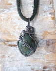Back angle view of emerald necklace for men with natural polished-raw emerald and detailed antiqued sterling silver craftsmanship