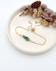 Handmade emerald bracelet displayed on ceramic tray showing natural green crystals and gold chain - May birthstone gift for her