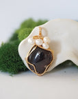 Detailed front angle of garnet and freshwater pearl pendant, gold wire wrapped, handcrafted gemstone jewelry