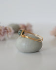 Side view of minimalist gold emerald ring showing classic artisan wire wrapping around a natural emerald bead.