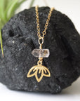 Detailed view of Herkimer diamond and lotus necklace in gold vermeil with natural raw crystal and symbolic lotus charm.