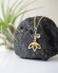 Zoomed out view of Herkimer diamond and lotus necklace in gold vermeil with minimalist artisan styling.