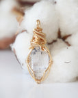 Back angle detail of raw Herkimer diamond pendant with intricate artisan wire wrapping in warm gold copper.