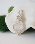 Left angle detail of handmade Herkimer diamond pendant highlighting soft silver copper wire artistry.