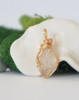 Back angle detail of herkimer diamond and freshwater pearl pendant, showing wire wrapping and natural stone