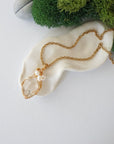 Herkimer diamond and freshwater pearl pendant on gold plated brass chain laying flat, handmade wire wrapped jewelry for women