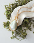 Jade and freshwater pearl pendant on gold plated brass chain laying flat, handmade wire wrapped jewelry for women