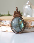 Labradorite necklace front view — polished-raw stone with blue teal flash, antique bronze wire wrapped pendant for women