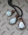 Three men's aquamarine pendants showing natural variation in aquamarine's shape, size, and blue color, Designs by Nature Gems