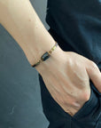 Men’s black tourmaline bracelet in antique bronze and brown leather, worn on the wrist