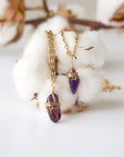 Two minimalist amethyst necklaces showing natural variation in raw amethyst pendant size, shape, and color, gold plated copper wire wrap