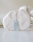 Back side angle of minimalist aquamarine necklace, showing simple wire wrapping and silver plated chain