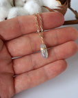 Minimalist aquamarine necklace in a hand for size reference, genuine aquamarine, warm gold artisan wire wrapping, Designs by Nature Gems