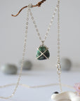 Back angle view of minimalist emerald necklace highlighting sterling silver prong setting and emerald pendant detail.