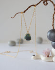 Zoomed out front view of minimalist emerald necklace in gold vermeil with natural emerald pendant.