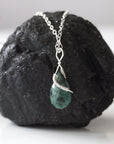 Back angle detail of minimalist emerald pendant necklace for women with natural faceted emerald and sterling silver craftsmanship