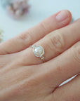 Sterling silver minimalist pearl ring shown on a model’s hand for everyday wear