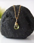 Front view of minimalist peridot pendant for women — faceted vivid lime green peridot with gold wire wrap bail, dainty 14k gold filled August birthstone necklace
